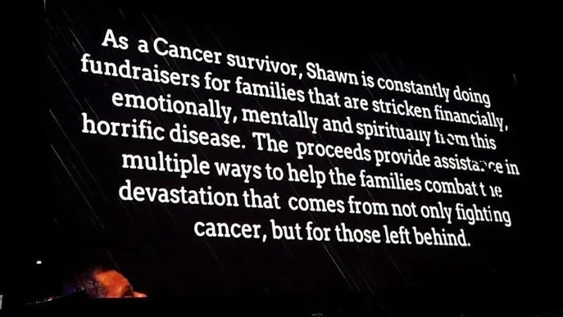 A large screen displays text about Shawn, a cancer survivor, raising funds for families stricken by the disease