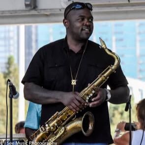 Jeremy Carter holding a saxophone on an outdoor stage