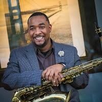 P. Manzell Bledsoe smiling and holding a saxophone
